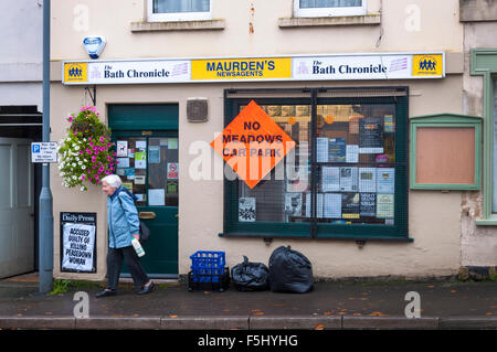 Batheaston, bagno, Somerset, Regno Unito. 5 novembre 2015. Segni di campagna per fermare il potenziale di creazione di un Parcheggio di Interscambio Autosilo su antiche prati di acqua in Bathampton vicino al bagno. Il bagno e il nord-est Somerset (pattini) County council deciderà la prossima settimana sulle proposte per il regime tra mille opposizioni locali. Una donna lascia un negozio locale del villaggio. Credito: Richard Wayman/Alamy Live News Foto Stock