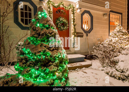 Una casa decorata con una ghirlanda, garland e le luci di Natale un una chiara notte d'inverno. Foto Stock