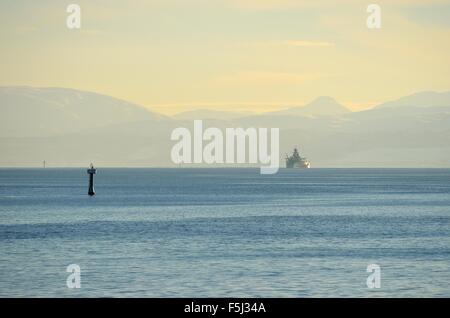 Naval coast guard ship out nel fiordo circondato da montagne imponenti Foto Stock