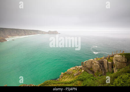 Nuvoloso vista verso Logan Rock da Porth Curno, Cornwall, Inghilterra Foto Stock