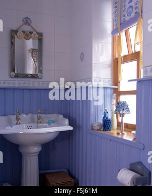 Piccolo specchio sopra lavello in un economia di bagno di stile con blue tongue+pannellatura scanalatura Foto Stock