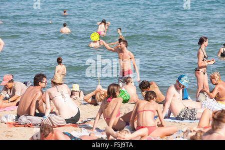 Bagni di sole, nuoto a urban beach, Barceloneta,Barcelona.avviso,pericolo,scottature,sun,bruciato,beach,Catalogna,Spagna. Foto Stock