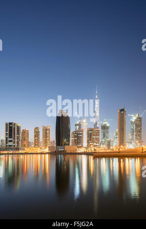 Skyline di torri si riflette nel torrente al crepuscolo in Business Bay in Dubai Emirati Arabi Uniti Foto Stock