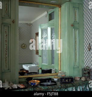 Turchese pallido calcare lavato antine su entrambi i lati dello specchio nel bagno degli anni novanta Foto Stock