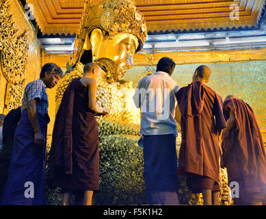 I monaci di applicare la foglia di oro per il Buddha Mahamuni,Mandalay,Myanmar (Birmania) Foto Stock