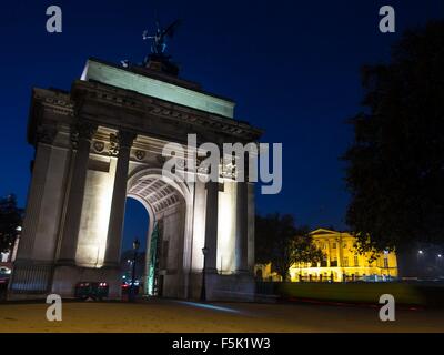 I ciclisti in sella attraverso Wellington Arch all'angolo di Hyde Park a Londra di notte Foto Stock