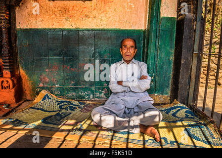 Anziani uomo seduto in strada di Kathmandu Foto Stock