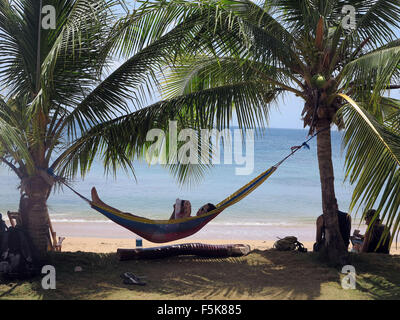 Little Corn Island, Nicaragua. 27 Mar, 2014. Un turista gode la lettura di un libro in una amaca tra due palme sulla piccola isola di mais. © Julie Rogers/ZUMA filo/Alamy Live News Foto Stock