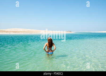 Donna in mare a Isola il Libano beach resort su un uomo fatto isola, parte del mondo fuori della costa di Dubai negli Emirati Arabi Uniti Foto Stock