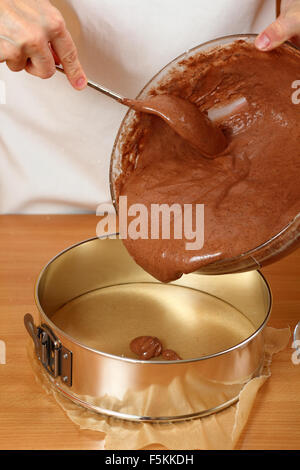 Versando cake mix in teglia (springform). Rendendo lo strato di cioccolato torta. Serie. Foto Stock