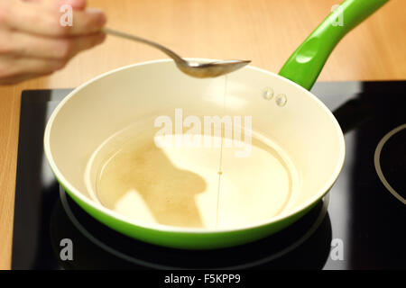 Versando olio vegetale in padella. Rendendo enchilada tortilla con carne di manzo. Serie. Foto Stock