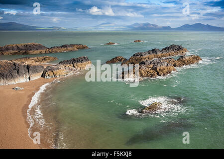 Da Llanddwyn Island cercando attraverso il Menai Straits verso le montagne del Galles del Nord Foto Stock