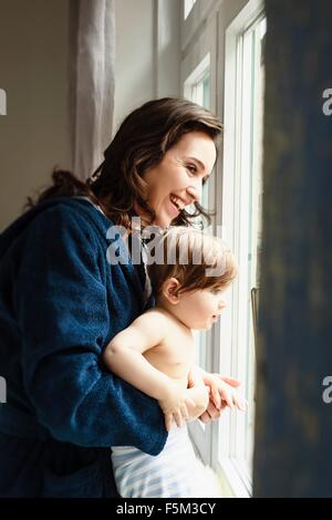 Il bambino e la madre figlio guardando attraverso la finestra Foto Stock