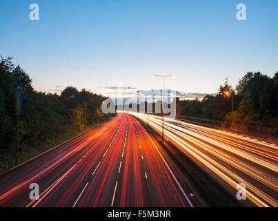 Vista in elevazione del traffico autostradale sentieri di luce al tramonto Foto Stock