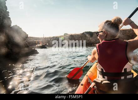 Vista posteriore della donna kayak di mare, Menorca, isole Baleari, Spagna Foto Stock