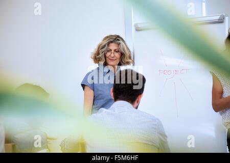 Senior donna presentando al team aziendale di Office Foto Stock