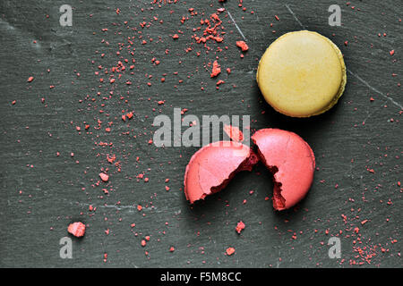 Alcuni appetitosi macarons di sapori diversi su una superficie di ardesia Foto Stock