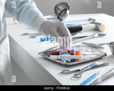 Patologo il prelievo di un campione per analisi durante una autopsia Foto Stock