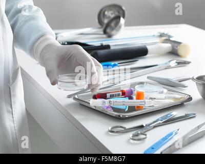 Patologo il prelievo di un campione per analisi durante una autopsia Foto Stock