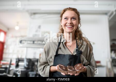 Giovane donna con stampa in rilievo in legno nel laboratorio di stampa Foto Stock