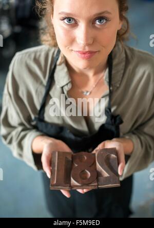 Donna che mantiene la stampa tipografica tradizionale workshop numeri Foto Stock