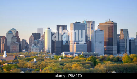 Il Governors Island e il Manhattan Financial District vista dal porto di New York al tramonto nella città di New York, Stati Uniti d'America. Foto Stock