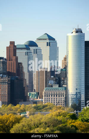 Il Governors Island e il Manhattan Financial District vista dal porto di New York al tramonto nella città di New York, Stati Uniti d'America. Foto Stock