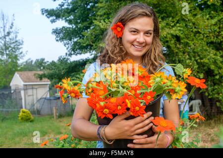 Ritratto di donna lavoratrice agricola tenendo un secchio di fiori recisi freschi Foto Stock