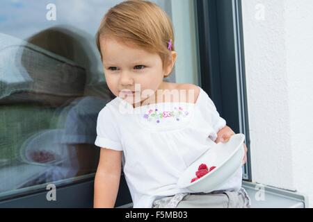 Ritratto di donna bambino sul patio mangiare coppa di lamponi Foto Stock