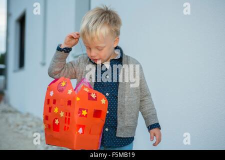 Ragazzo che trasportano fatta in casa lanterna di natale sul patio Foto Stock