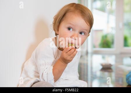 Ritratto di donna bambino mangiare prugna in cucina Foto Stock