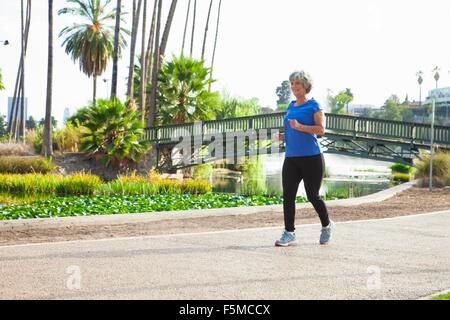 Donna matura a fare jogging nel parco Foto Stock