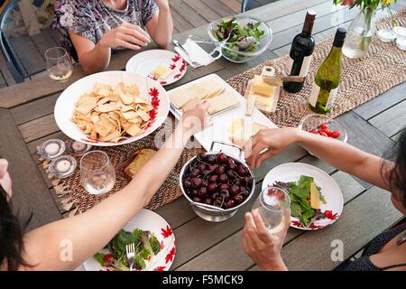 Ritagliato vista aerea di amici di sesso femminile di mangiare il pranzo sul patio Foto Stock