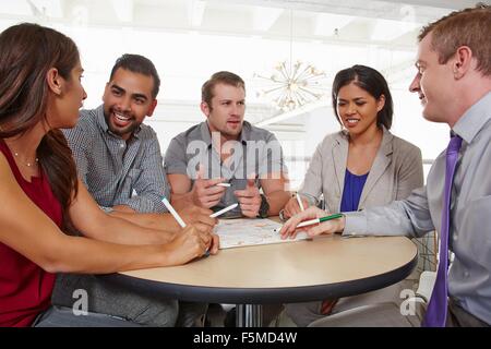 Piccolo gruppo di persone aventi il brainstorming meeting aziendali Foto Stock