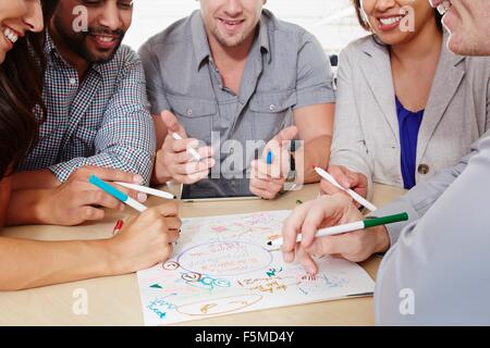 Piccolo gruppo di persone aventi il brainstorming meeting aziendali Foto Stock