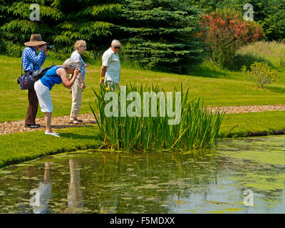 Turisti che si godono una passeggiata intorno al lago a Hopton Hall giardino nel Derbyshire Dales Peak District Inghilterra REGNO UNITO Foto Stock