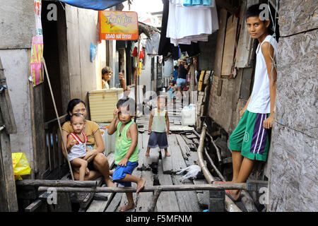 Manila nelle Filippine: residente di un quartiere povero che vivono in capanne su palafitte sopra l'acqua, Tondo township, Manila, Filippine Foto Stock