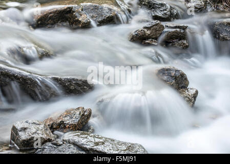 L'acqua che scorre sulle rocce nel ruscello di montagna Foto Stock