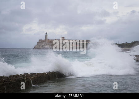 Onde che si infrangono vicino al Malecon con Morro Castle in background, Havana, Cuba Foto Stock