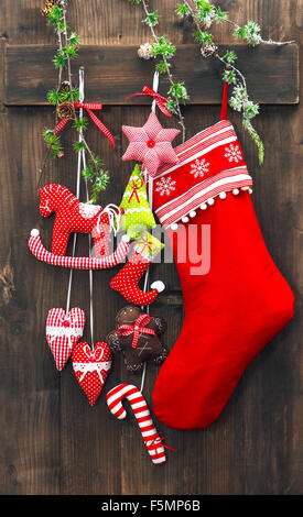 Decorazione di Natale calza e giocattoli fatti a mano su legno rustico sfondo. Ornamenti di festa Foto Stock