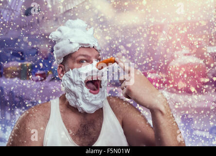 Uomo sorridente con schiuma da barba punti presso il suo naso di carota su sfondo inverno Foto Stock