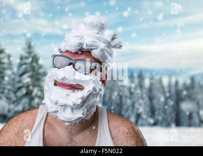 Strano uomo sorridente in bicchieri con schiuma da barba sul suo volto su sfondo inverno Foto Stock