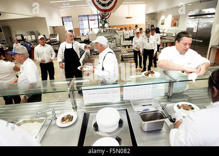 Yountville, CA, Stati Uniti d'America. 4 Novembre, 2015. Lo Chef Kevin Miller, diritto di Vintage station wagon, prepara un piatto per il servizio all'undicesima edizione del celebrity chef veterani giorno pranzo presso la casa dei veterani della California a Yountville mercoledì. © Napa Valley Register/ZUMA filo/Alamy Live News Foto Stock