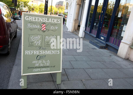 Un segno sulla strada per un tradizionale inglese barbieri shop, Greenslades a Bristol, Inghilterra, Regno Unito GB Foto Stock