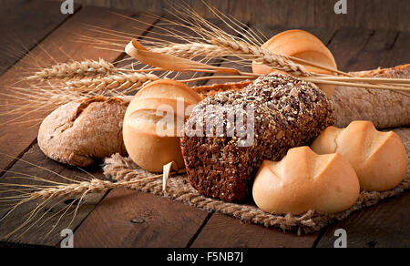 Assortimento di pane cotto su di un tavolo di legno Foto Stock