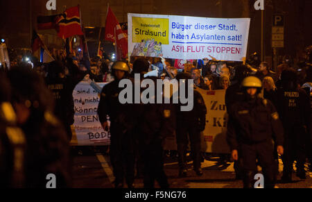 Stralsund, Germania. 6 Nov, 2015. I partecipanti tenere un banner che recita "Asylantenstadt Stralsund - Buerger dieser Stadt, haben Asylanten satt! - Asylflut stoppen!" (città di asilo Stralsund - i cittadini di questa città sono malati di richiedenti asilo! - Arrestare il diluvio di asilo!) nel corso di una manifestazione dal titolo "V wehrt sich' (Meclemburgo-Pomerania combatte indietro) per protestare contro la politica dei rifugiati del governo tedesco, a Stralsund, Germania, 06 novembre 2015. Circa 400 dimostranti sono stati di fronte alcuni 300 contro i manifestanti, secondo la polizia. Foto: Stefan Sauer/dpa/Alamy Live News Foto Stock