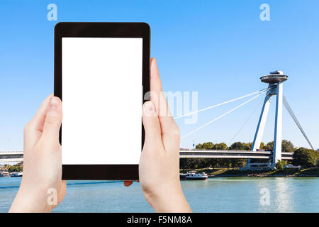 Concetto di viaggio - fotografie turistiche di SNP Bridge (ponte di UFO, Novy più, ponte nuovo) oltre il fiume Danubio a Bratislava su tablet Foto Stock