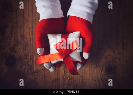 Vigilia di Natale regalo, mani dando avvolto presente, vista dall'alto dai toni rétro immagine con il fuoco selettivo Foto Stock