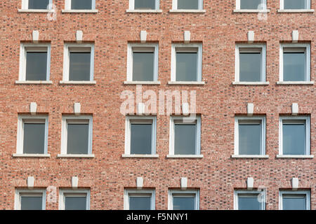 Rosso la parete in mattoni con file di windows esterno dell'edificio full frame. Foto Stock