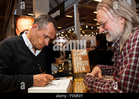 Copenhagen, Danimarca, Novembre 7th, 2015. Autore danese Carsten Jensen (L) i segni del suo nuovo libro "Den Første Sten" (leggere: la prima pietra") circa la guerra e i soldati danesi in Afghanistan. a Copenaghen Salone circa il suo nuovo libro, Credito: OJPHOTOS/Alamy Live News Foto Stock